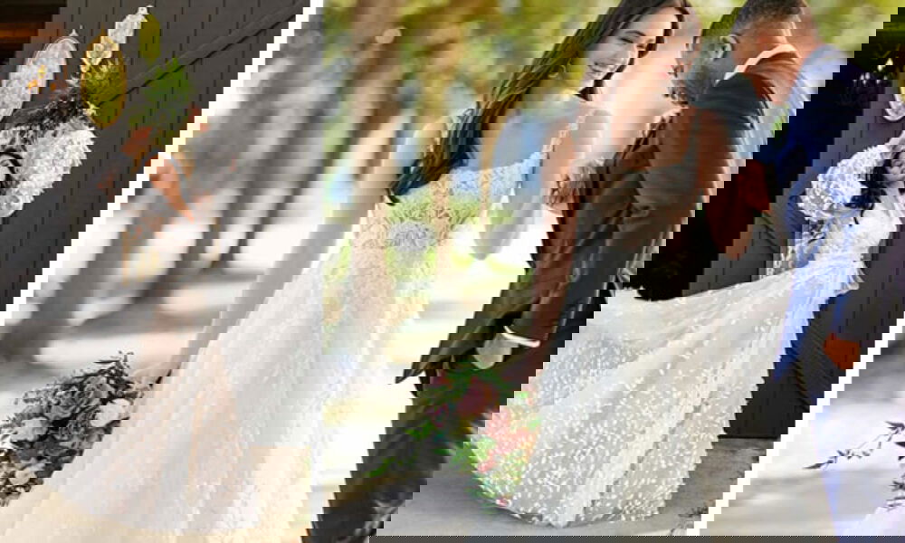 Links: Braut in einem luftigen, geblümten Kleid mit auffälligen Puffärmeln posiert selbstbewusst vor einer dunklen Scheune. Rechts: Eine Braut in einem bestickten, ärmellosen Kleid hält einen Blumenstrauß und interagiert liebevoll mit ihrem Bräutigam, der sich zu ihr herunterbeugt.