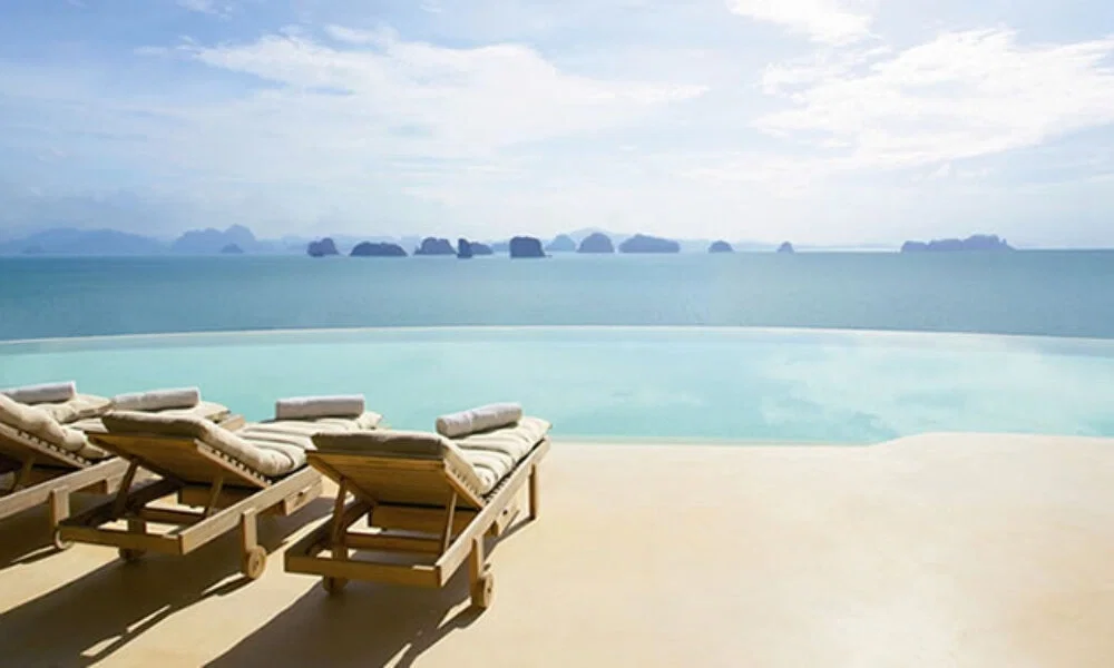 Infinity Pool mit Meerblick und gemütlichen Liegen im Vordergrund, perfekt für eine entspannte Auszeit mit Blick auf thailändische Inseln.
