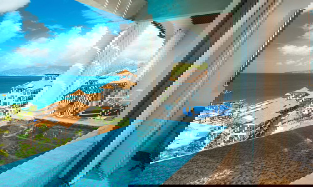 Intimer Pool auf einer Suite-Terrasse mit atemberaubendem Ausblick auf das Meer und benachbarte karibische Villen bei sonnigem Wetter.