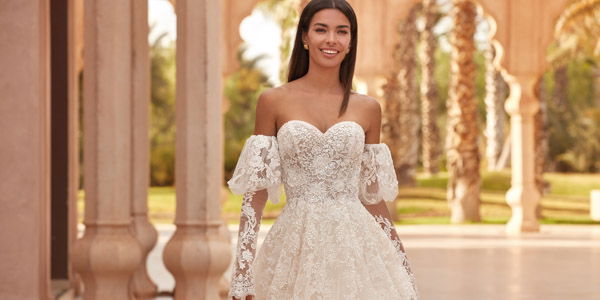 Traumhaftes Brautkleid mit schulterfreien Puffärmeln und filigraner Spitze, perfekt für eine romantische Hochzeit im Freien.