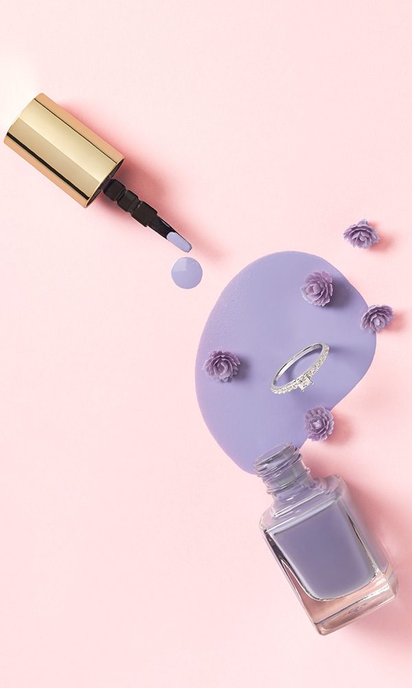Stilvolle Detailaufnahme mit violettem Lack, Mini-Blüten und Ehering für die Wedding-Maniküre.