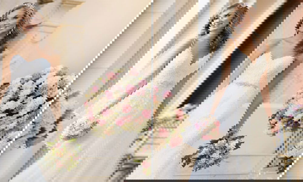 Stilvolle Hochzeitsaufnahmen von Bräuten in Stella-York-Kleidern mit Spitze und Blumenmotiven, dekoriert mit Rosenarrangements in Rosa und Creme.