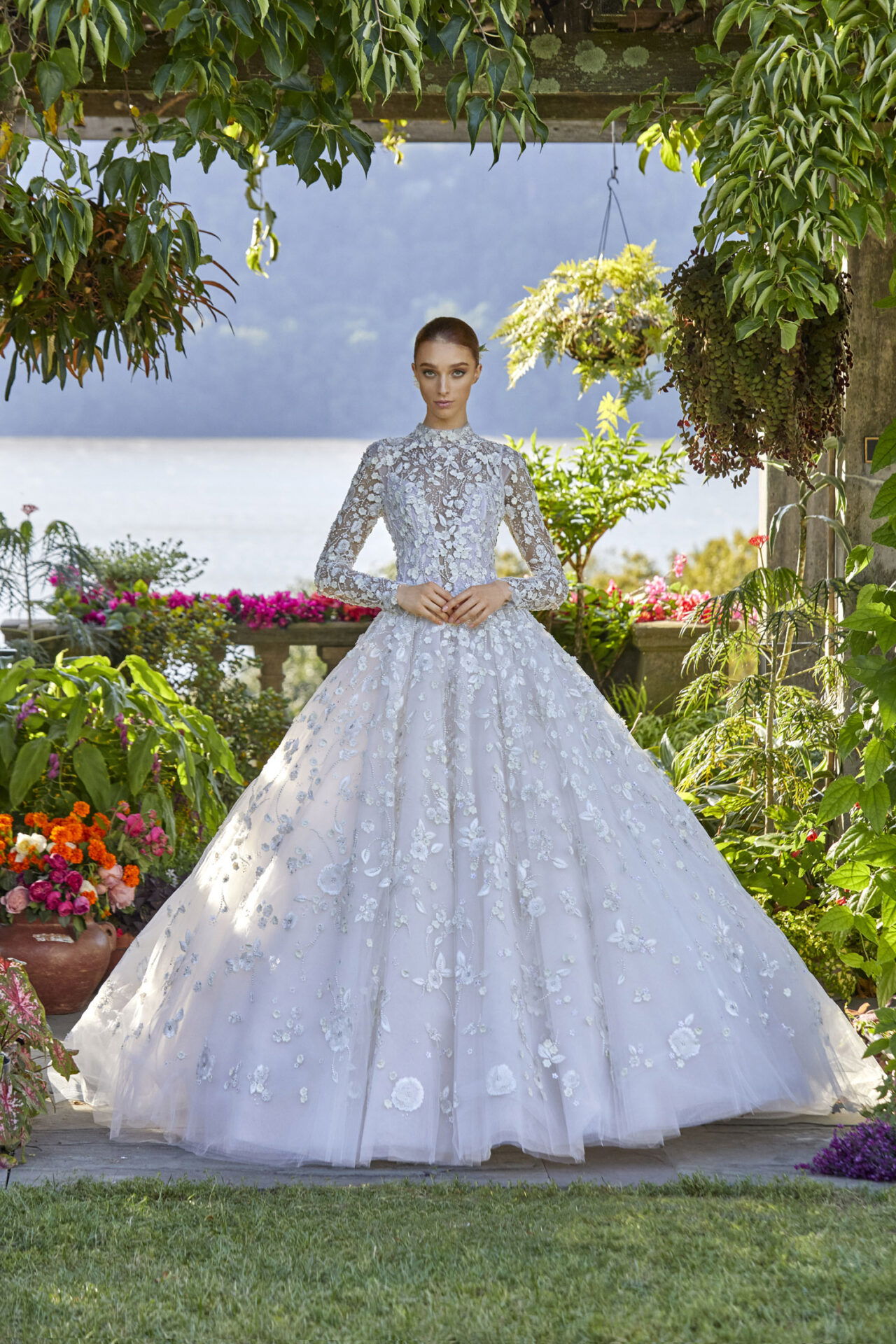 Romantisches Brautkleid aus Spitze mit langen Ärmeln und Blumendetails, perfekt für eine klassische Prinzessinnenhochzeit.