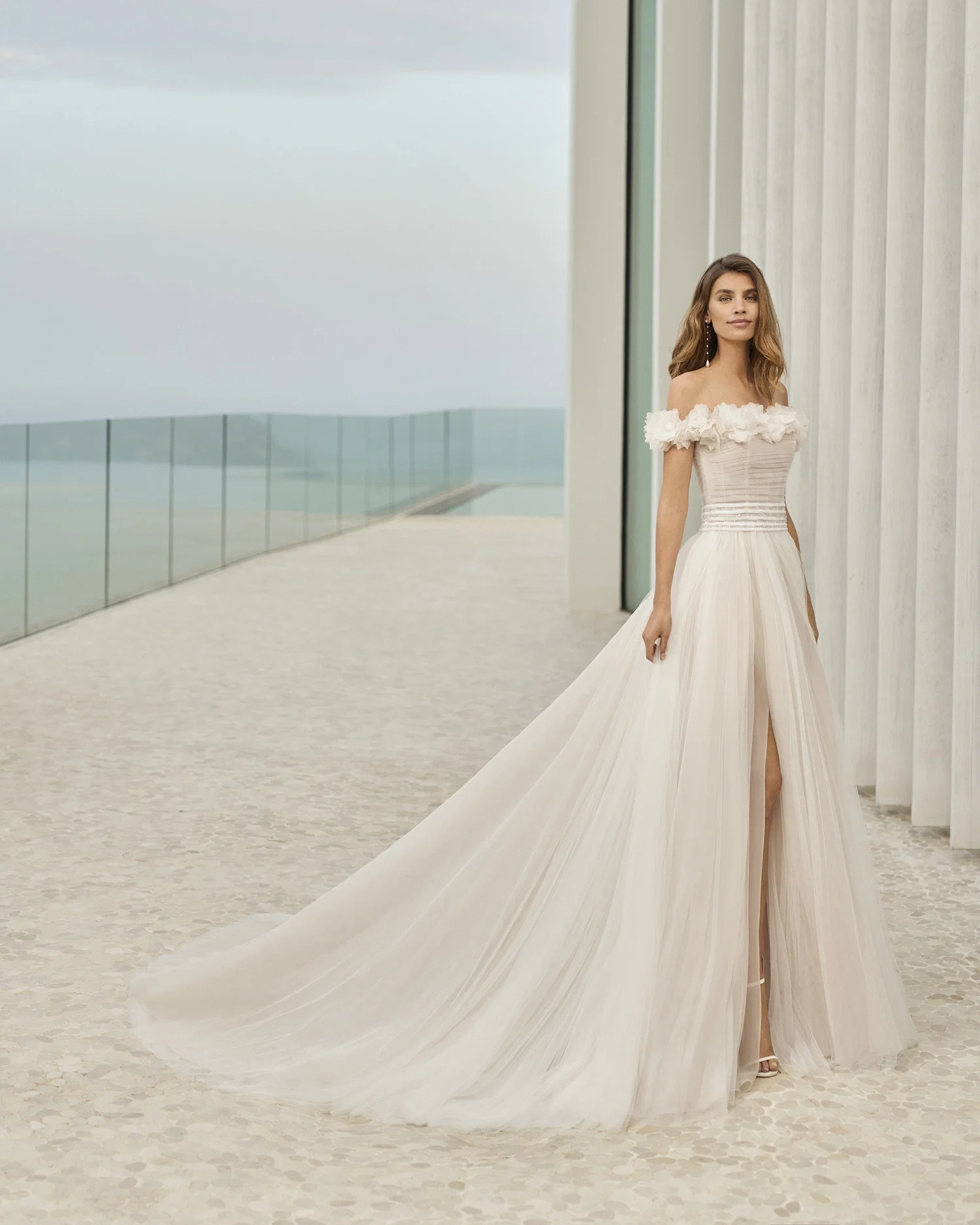 Eine Braut in einem romantischen, trägerlosen Tüllkleid, das durch seine fließenden Linien und den märchenhaften Rock verzaubert.