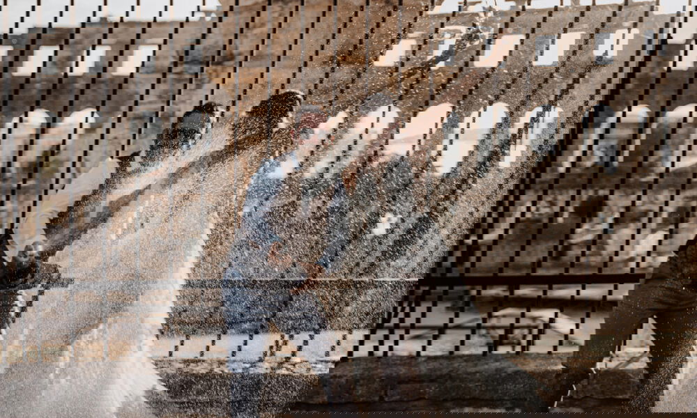 Ein Brautpaar versprüht Champagner vor einer alten Ruinenkulisse. Der Bräutigam mit Sonnenbrille und Weste, die Braut in einem Hochzeitskleid, beide genießen den Moment in voller Freude.