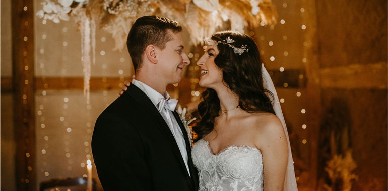 Braut und Bräutigam genießen einen besonderen Moment in festlicher Hochzeitsdekoration mit funkelnden Lichtern, die den Raum erhellen.