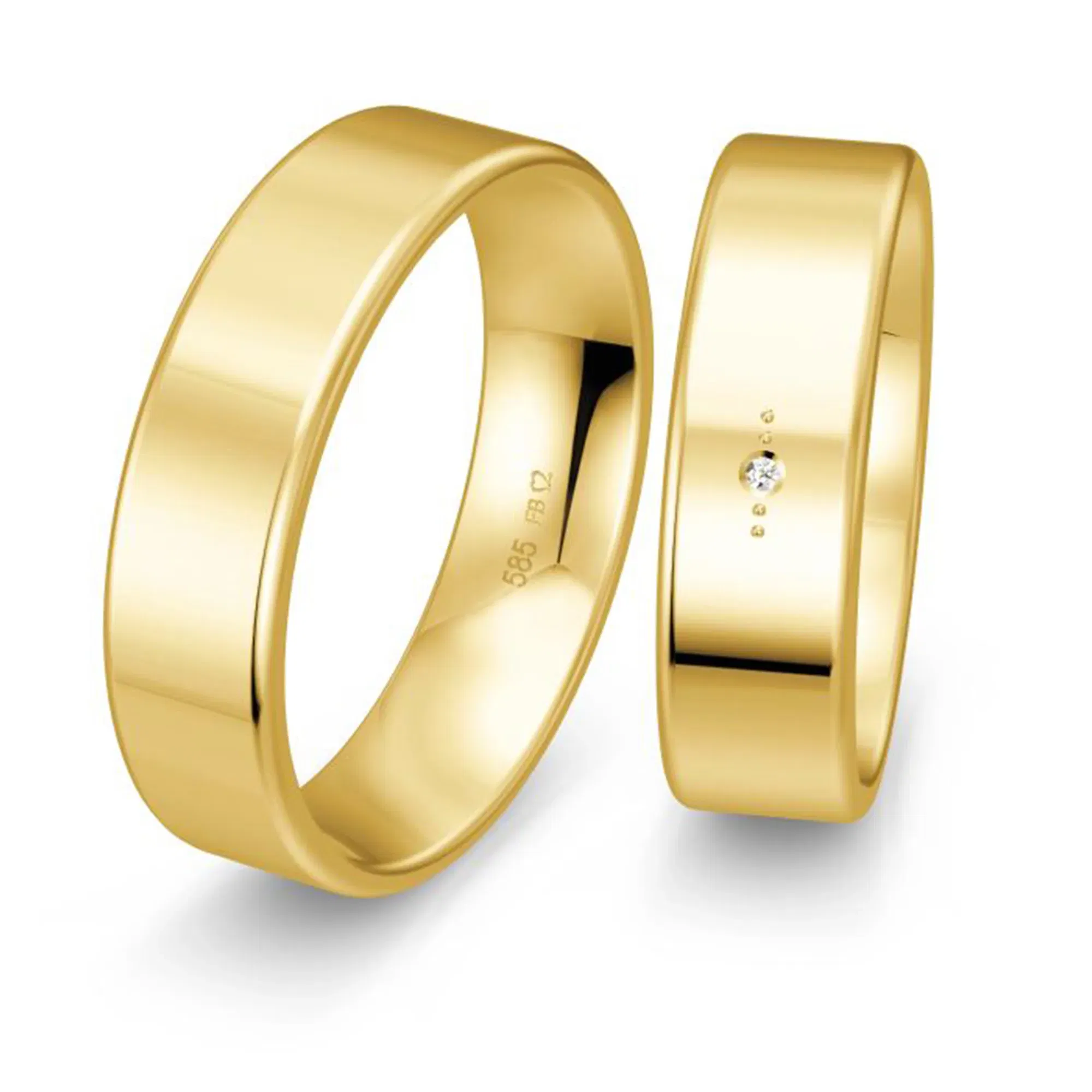Schlichtes und edles Trauring-Set aus Gold, mit einem Ring, der einen einzelnen funkelnden Diamanten als Akzent trägt, dargestellt vor einem neutralen Hintergrund.