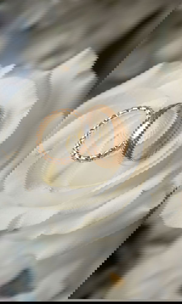 Ein romantisches Ringset, liebevoll in die Blätter einer weißen Rose gelegt. Die Kombination aus glänzendem Roségold und der natürlichen Eleganz der Blüte verleiht dem Bild eine emotionale Tiefe.