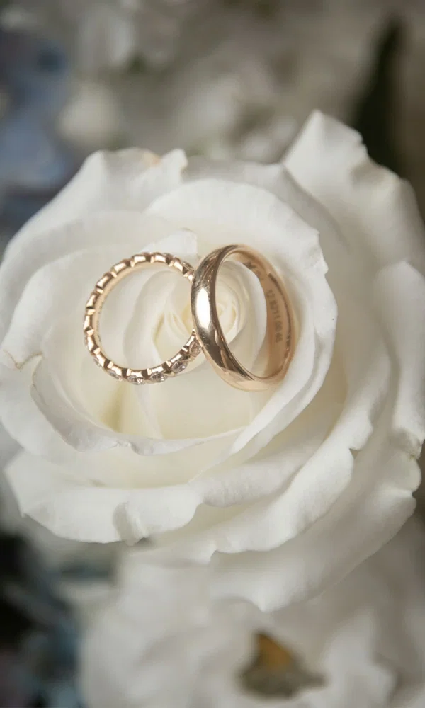 Ein romantisches Ringset, liebevoll in die Blätter einer weißen Rose gelegt. Die Kombination aus glänzendem Roségold und der natürlichen Eleganz der Blüte verleiht dem Bild eine emotionale Tiefe.
