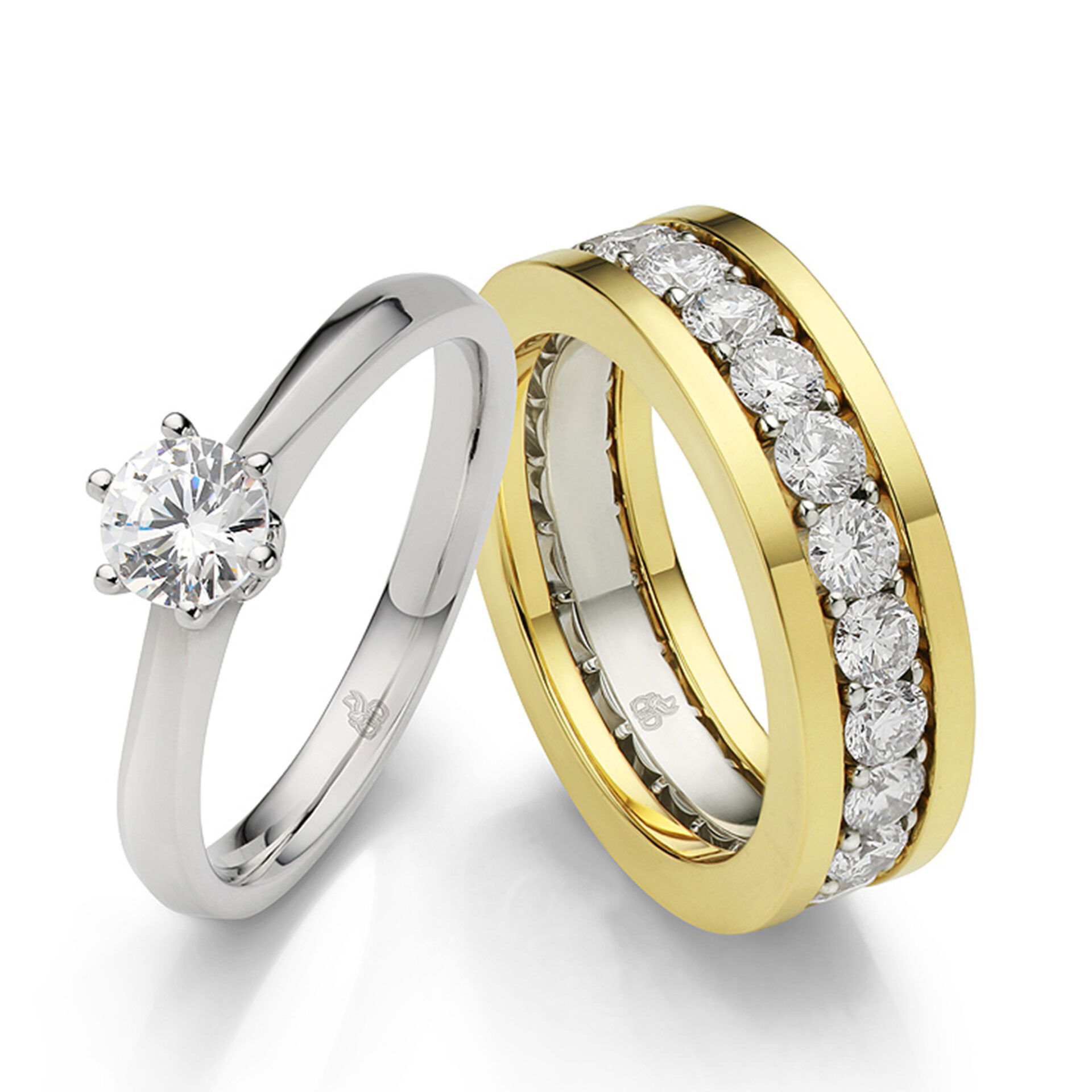 Zwei luxuriöse Ringe: Ein Solitärring aus Weißgold mit einem funkelnden Diamanten und ein massiver Gelbgoldring, verziert mit einer Diamantreihe entlang des Rings.