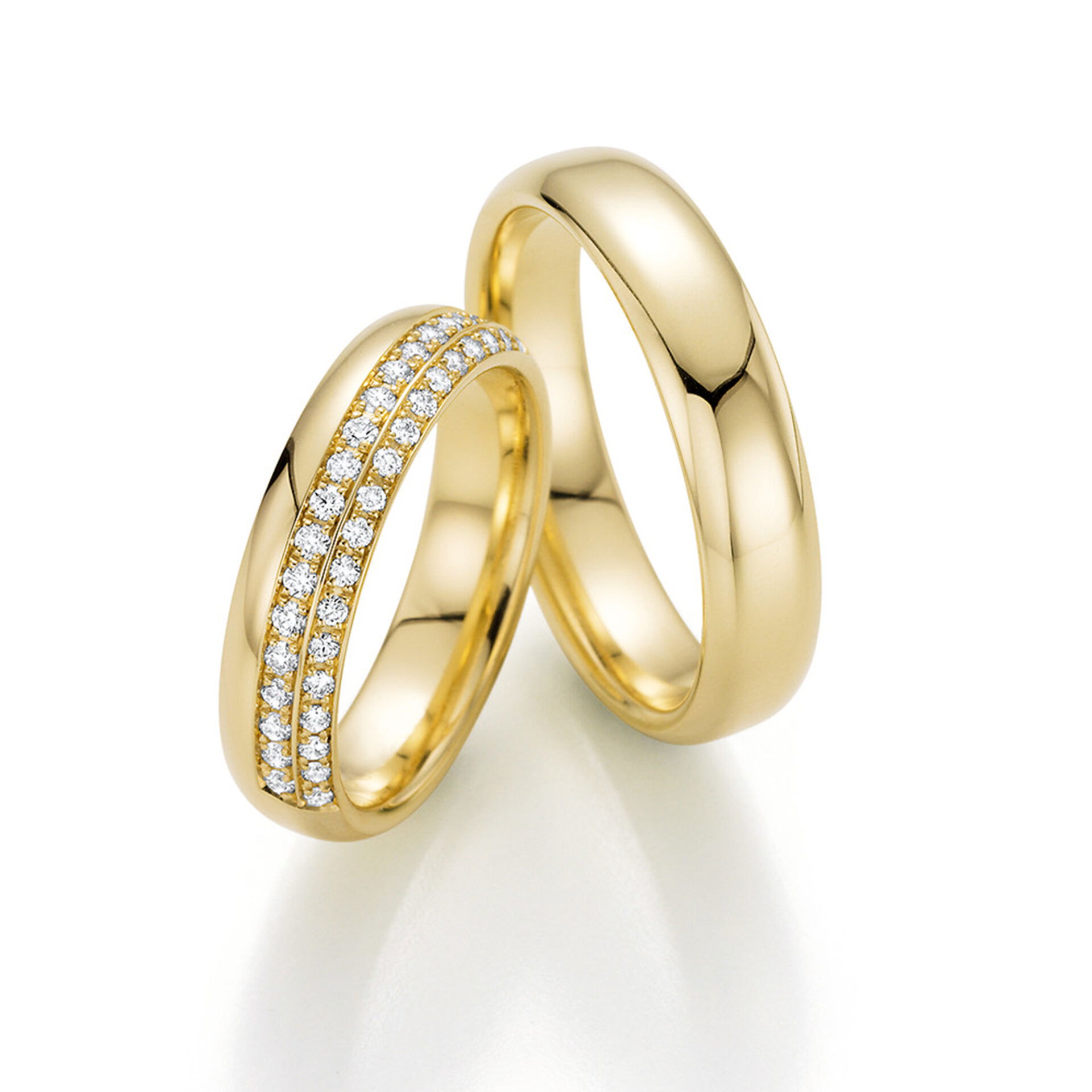 Zwei goldene Eheringe: Der eine ist klassisch glatt, während der andere mit zwei schimmernden Diamantreihen verziert ist, die einen funkelnden Kontrast schaffen.