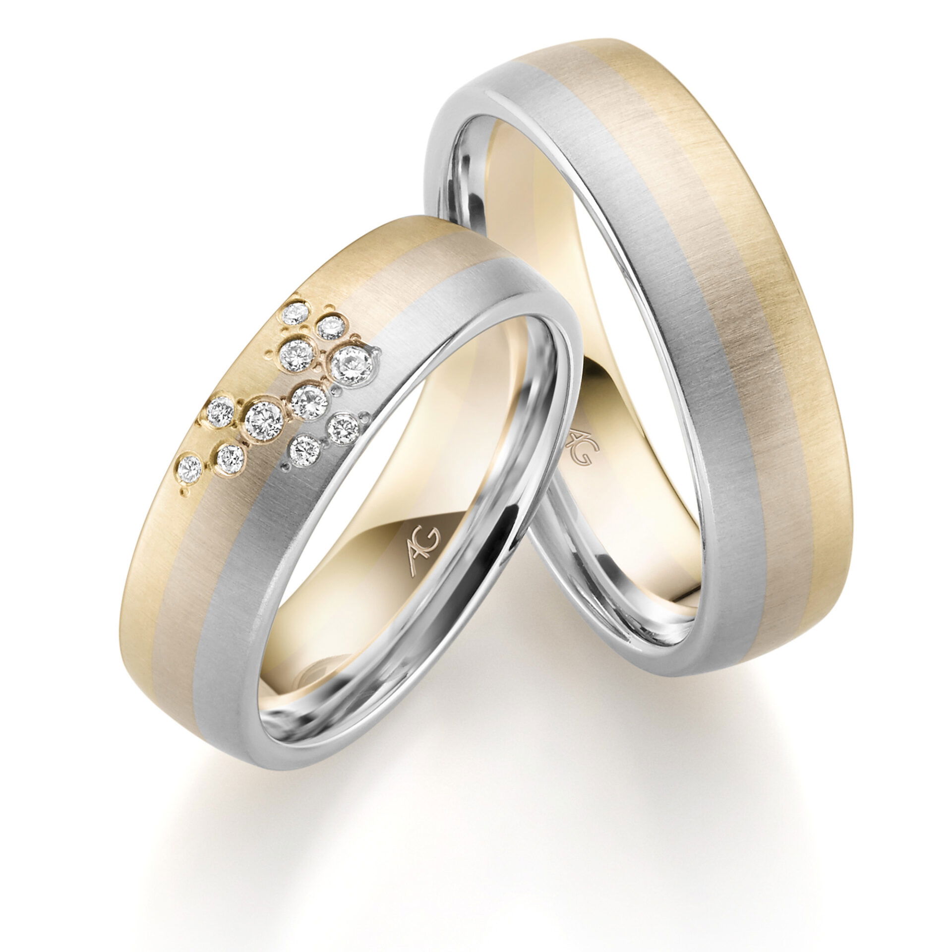 Zwei elegante Eheringe mit einer Kombination aus glänzendem Weißgold und mattem Gelbgold. Einer der Ringe ist mit einem Cluster kleiner Diamanten dekoriert, die eine verspielte Note verleihen.