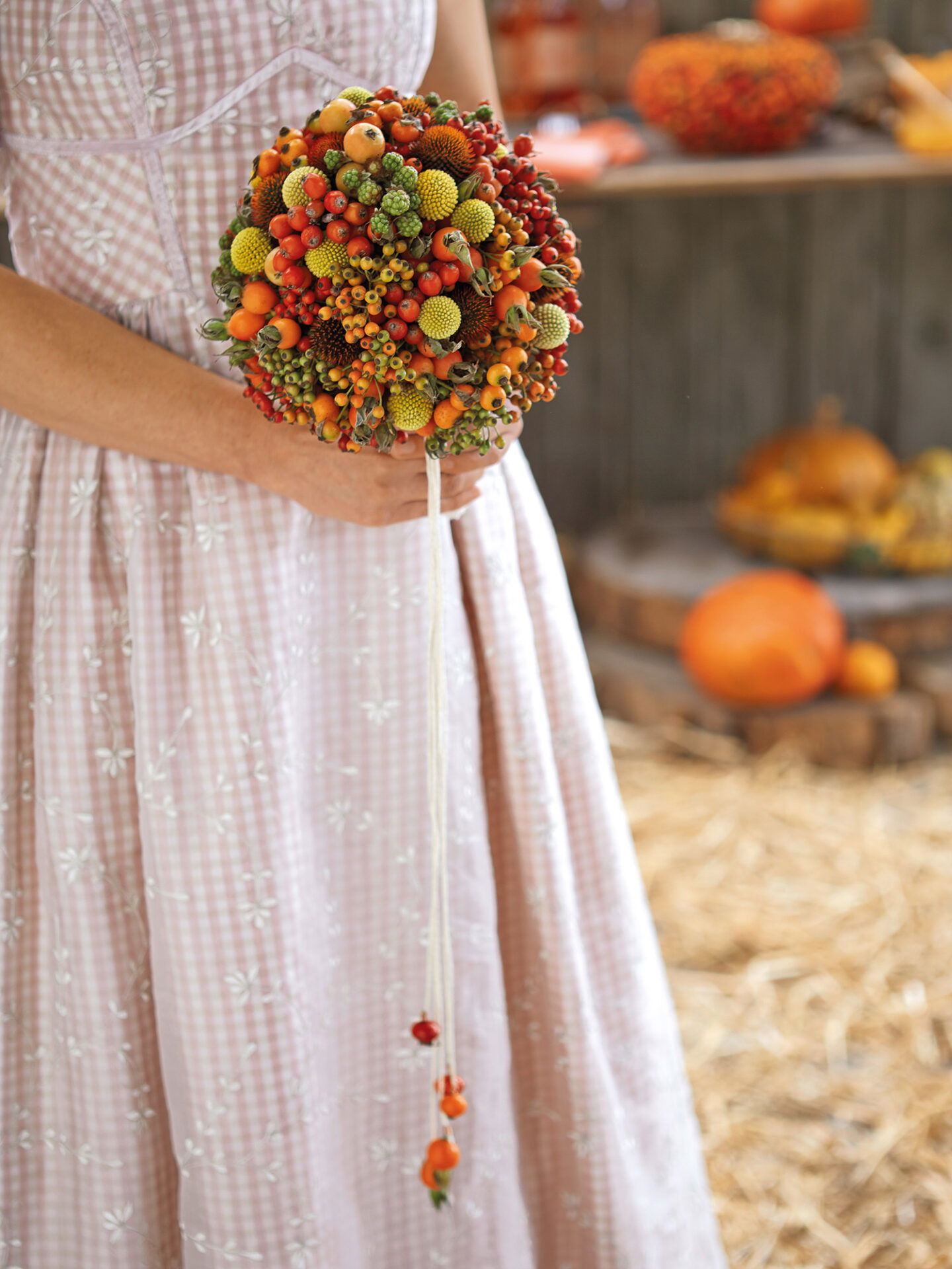Ein einzigartiger Brautstrauß aus bunten Beeren und Früchten, der wunderbar die Farben des Herbstes für eine rustikale Hochzeit widerspiegelt.