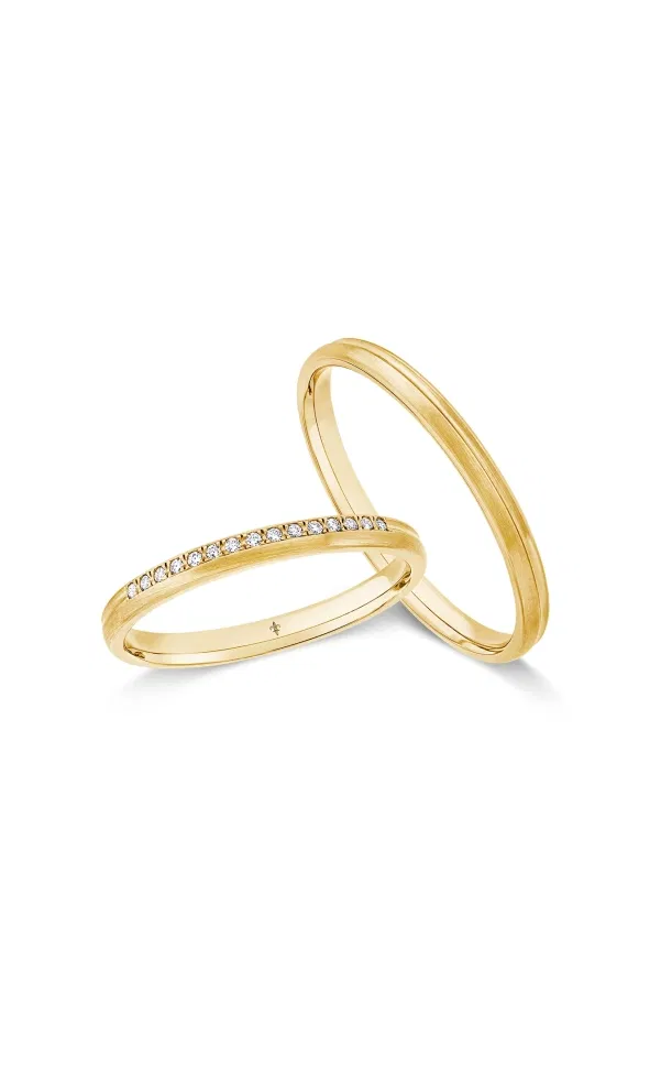 Zwei elegante Eheringe aus Gelbgold, einer davon mit einer feinen Reihe eingefasster Diamanten, modern und hochwertig vor hellem Hintergrund inszeniert.