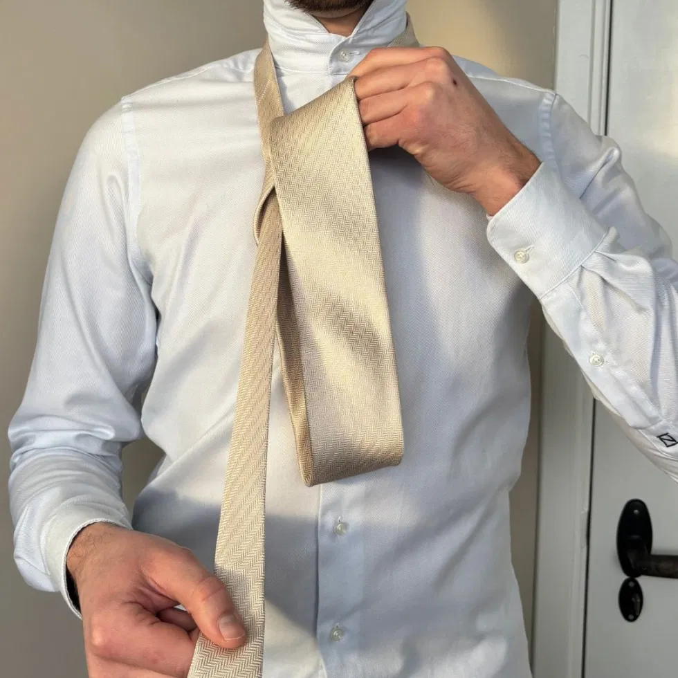 Die breite Seite der Krawatte wird erneut über die Vorderseite geführt, sodass eine Schlaufe entsteht.