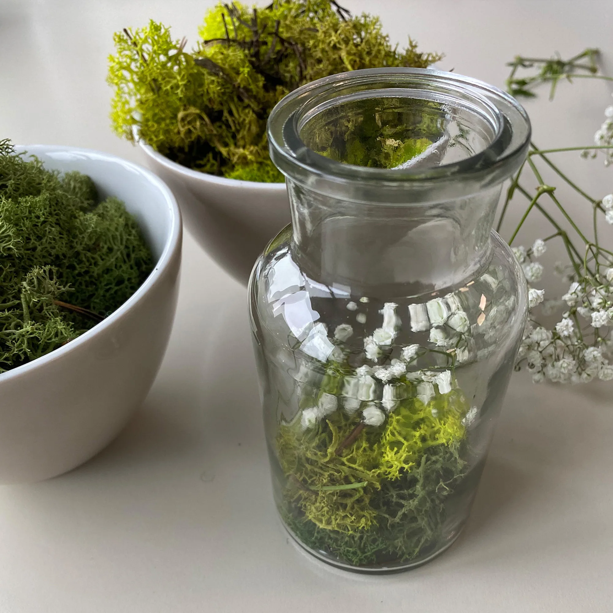 Flasche mit Moos und Schleierkraut dekoriert