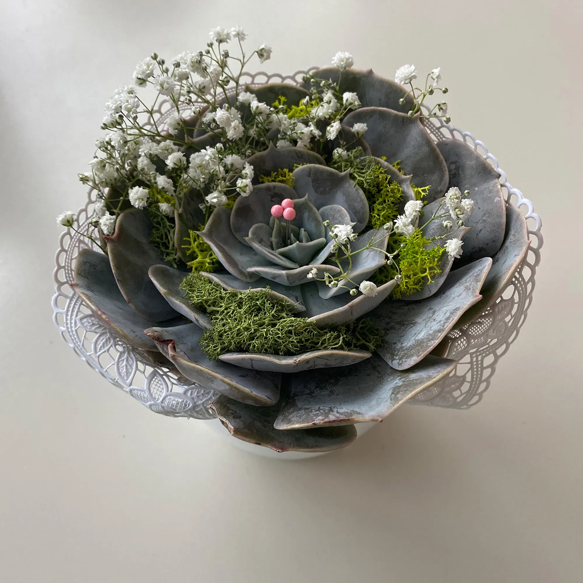 Sukkulente mit Spitze, Schleierkraut und Moos verziert