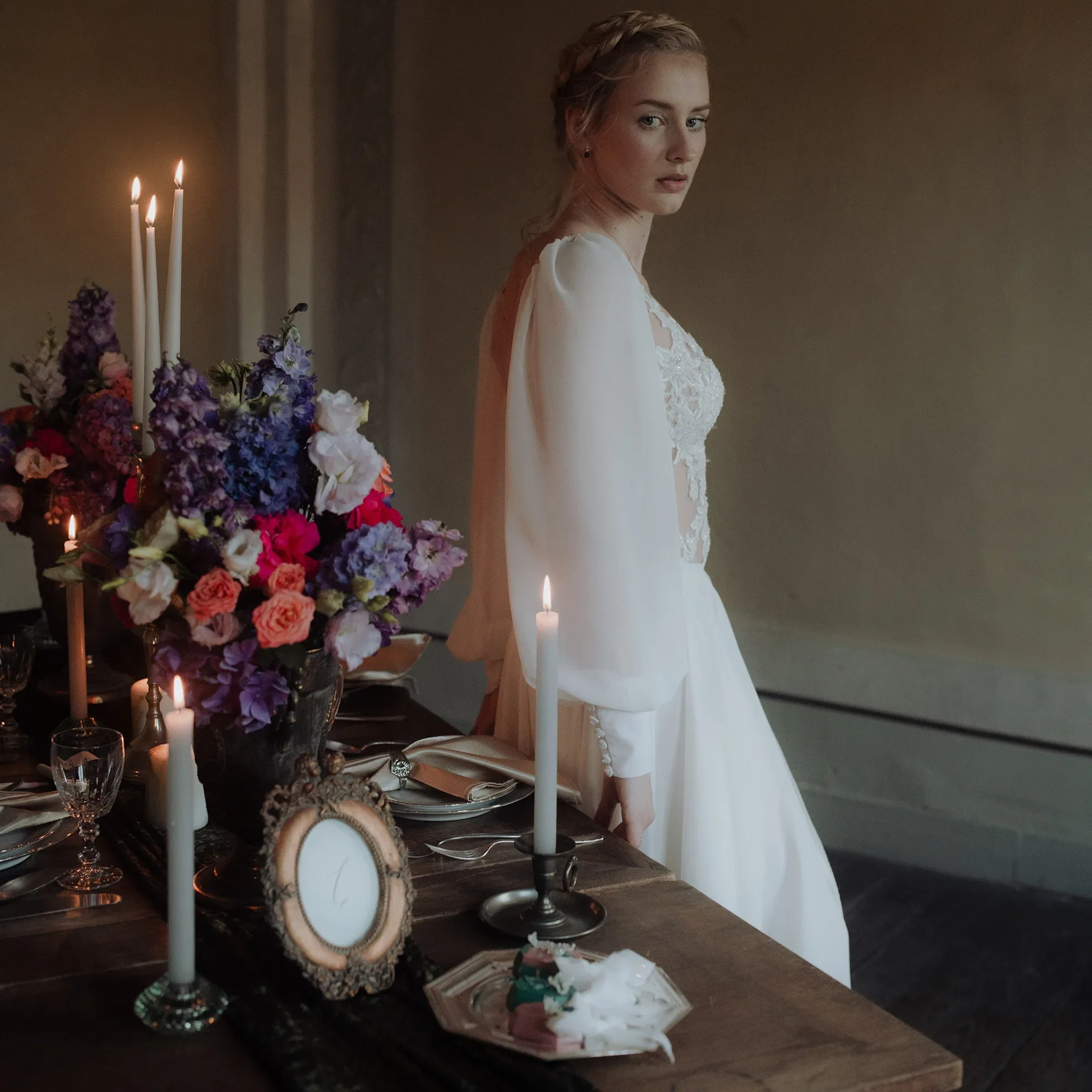 Braut im Hochzeitskleid vor gedecktem Tisch - Hochzeitsdeko im Kunst-Stil