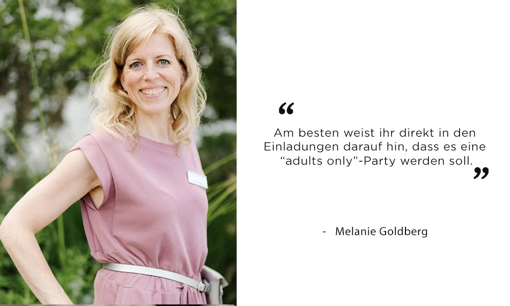 Melanie Goldberg mit blonden Haaren in einem rosa Kleid, draußen vor grüner Natur. Ihr Zitat rät, den „adults only“-Hinweis direkt in die Hochzeitseinladung zu integrieren.