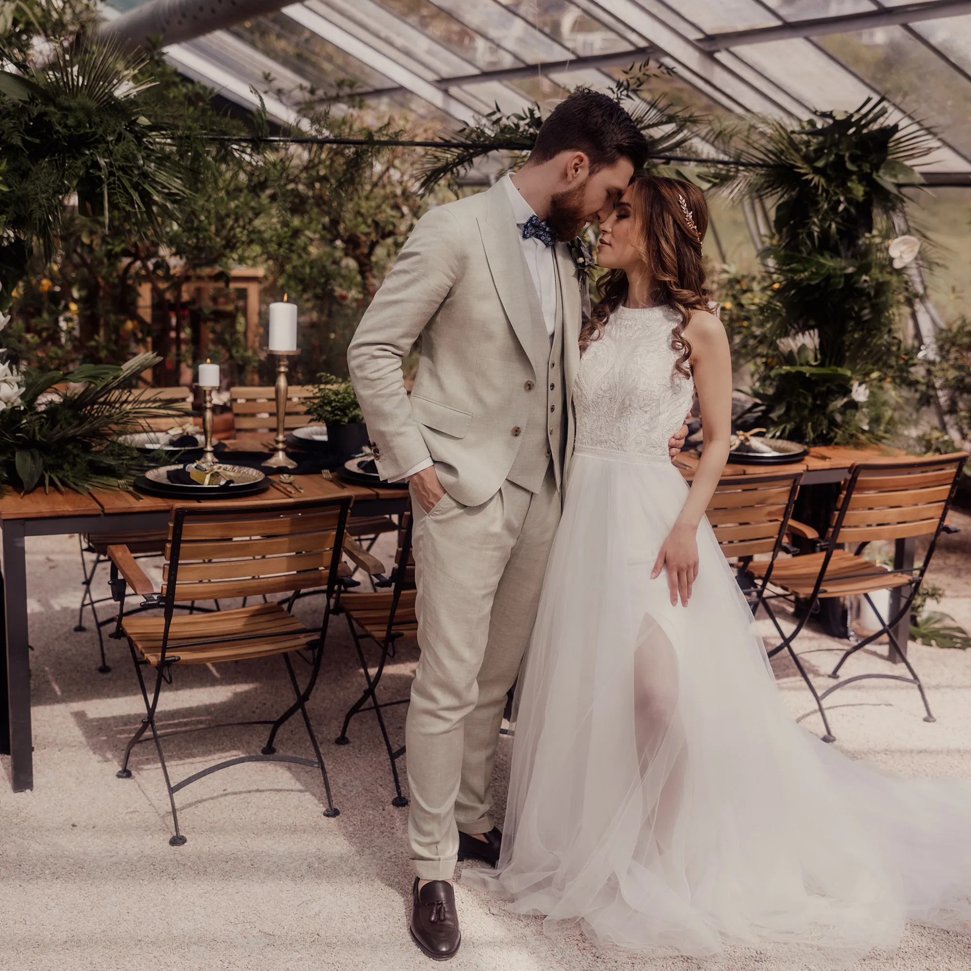 Hochzeitspaar im Gewächshaus vor gedeckter Tafel