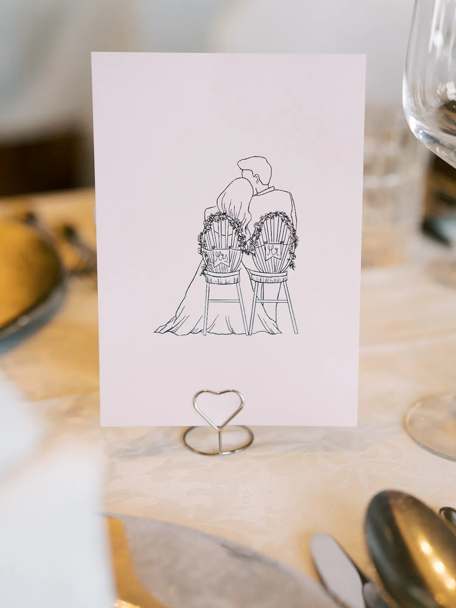 Minimalistische Hochzeitskarte mit der Illustration eines Brautpaares, das auf verzierten Stühlen sitzt, platziert auf einem dekorierten Hochzeitstisch.