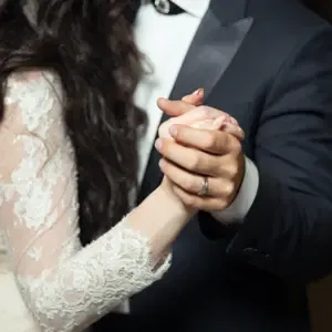 Brautpaar Tanzend mit ineinander liegenden Händen, abgebildet von Bauch bis Hals.