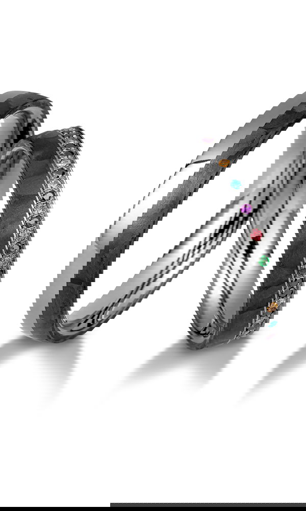 Außergewöhnliches Ehering-Duo aus Carbon und glänzendem Metall. Der Damenring beeindruckt mit einer filigranen Fassung aus bunten Edelsteinen, während der Herrenring mit seinem markanten Design eine moderne Note setzt.