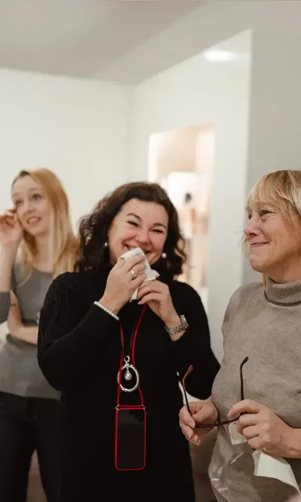 Emotionale Momente bei der Hochzeitskleidanprobe, als Freundinnen der Braut vor Freude lachen und weinen.