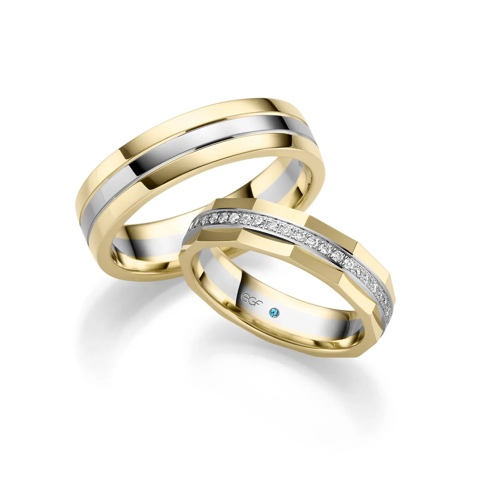 Trauringe in zwei Goldfarben. Der Frauenring ist mit einer Diamantenreihe bestückt.