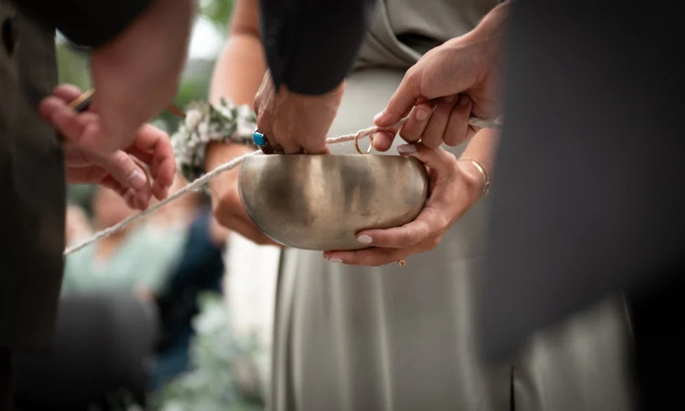 Hochzeitstraditionen werden bei einer freien Zeremonie durchgeführt. Die Ringe der Brautpaare werden mit einer Schnur zusammengeschnürt.