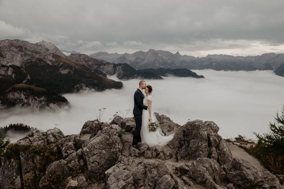 Hochzeitspaar vor Bergkulisse.