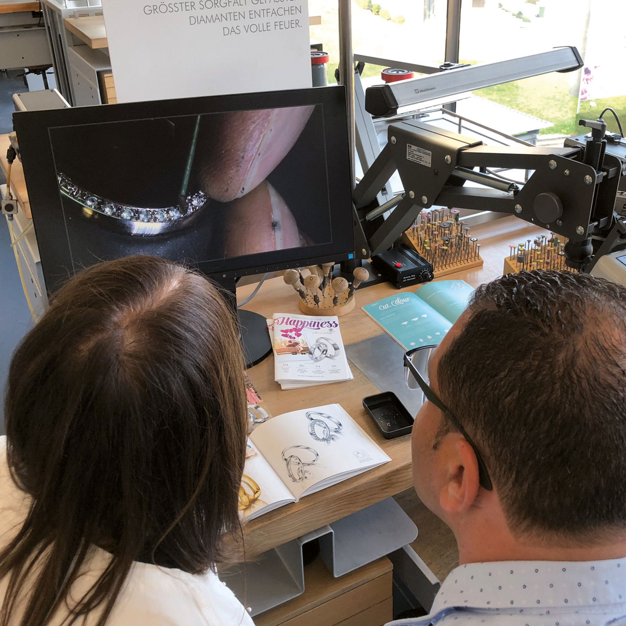 Zwei Personen schauen auf einen Monitor, auf dem ein Ring zu sehen ist.