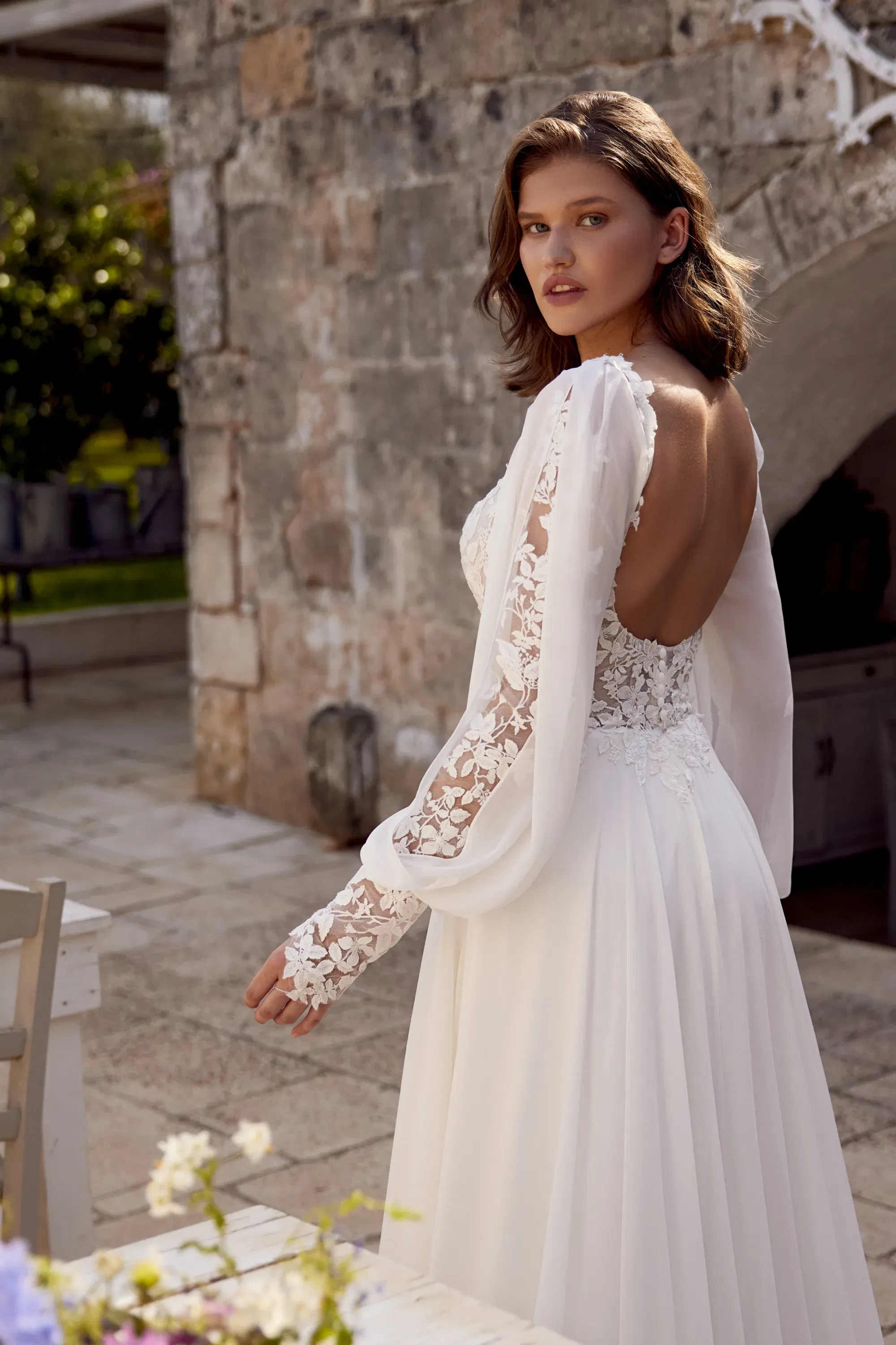 Rückenansicht eines Boho-Kleids mit floraler Spitze, Knopfleiste und leicht ausgestellter Schleppe – verspielt und natürlich.