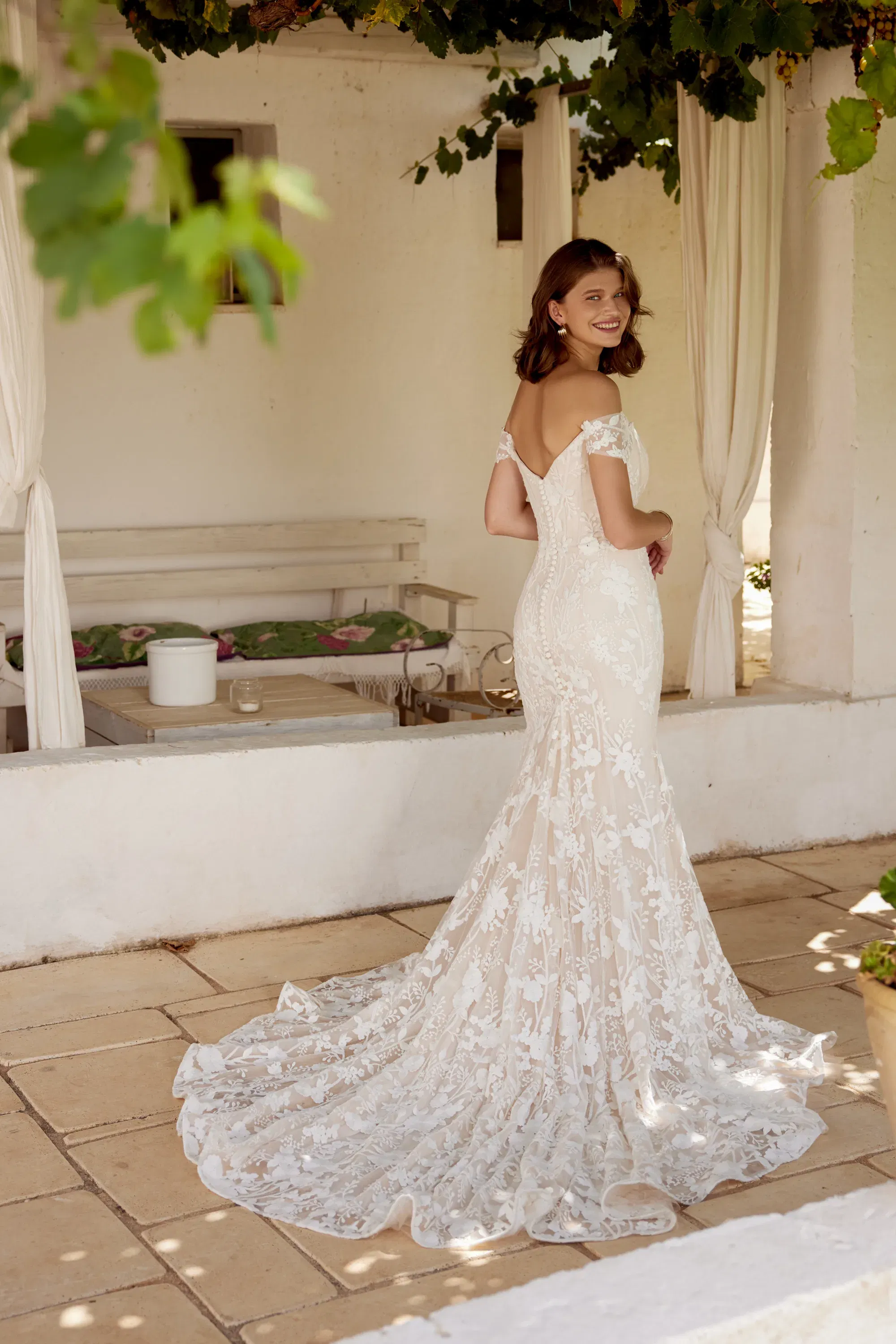 Rückansicht eines figurnahen Brautkleides mit floralen Spitzenmustern und tiefem Rückenausschnitt – stilvoll und romantisch.