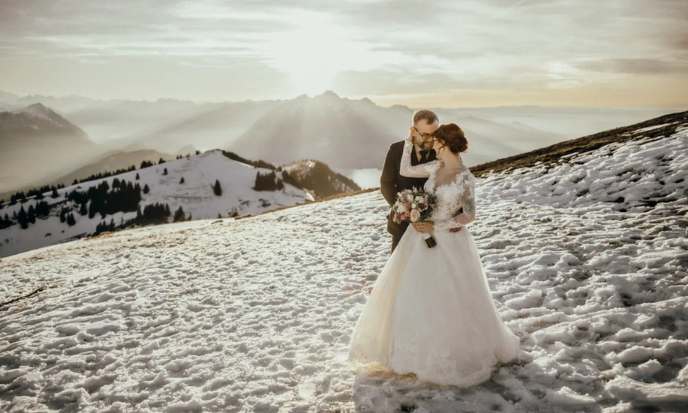 Das frisch verliebte Brautpaar im Schnee auf der Rigi. Im Hintergrund der Sonnenuntergang.
