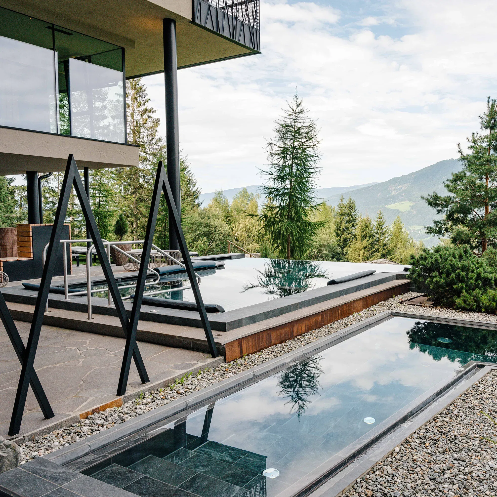 Außenbereich des Baumhotels My Arbor mit einem Whirlpool und Blick auf die umliegende Südtiroler Berglandschaft.