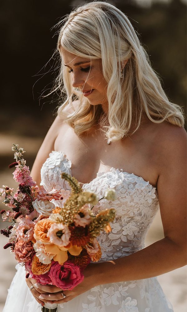 Die Braut hält ihren kunstvoll arrangierten Blumenstrauß während einer emotionalen Pause.