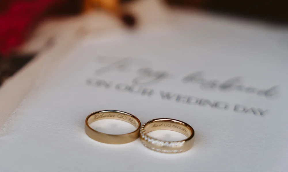 Detailaufnahme der Hochzeitsringe von Katharina und Marcel auf eleganter Papeterie.