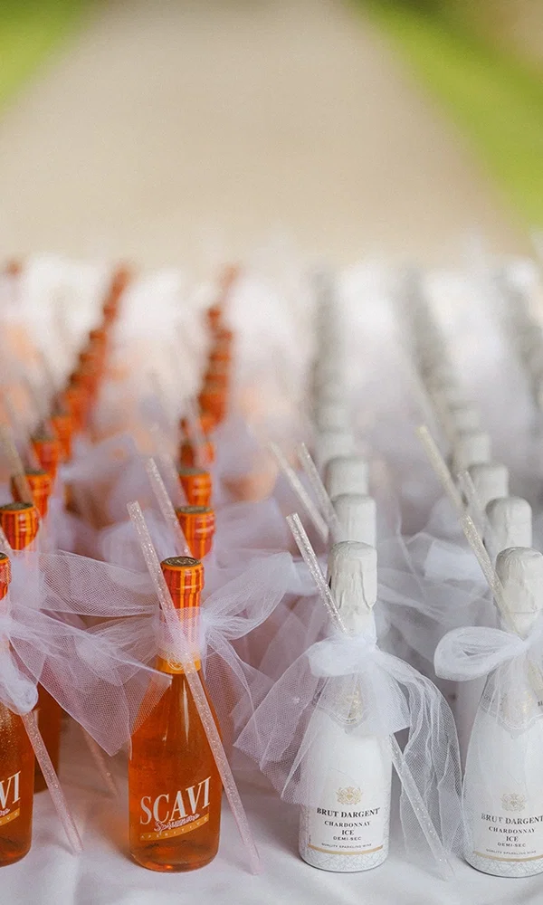 Champagnerflaschen und Erfrischungen mit kreativen Details für die Hochzeitsfeier.