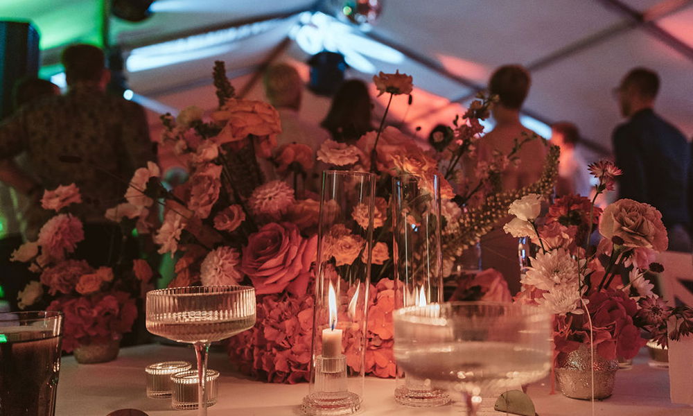 Elegante Tischdekoration mit Blumen und Kerzen auf einer stimmungsvollen Hochzeit.
