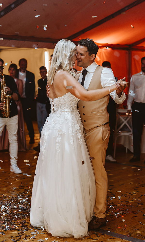 Hochzeitstanz des Brautpaares in einem festlich dekorierten Zelt mit musikalischer Live-Begleitung.