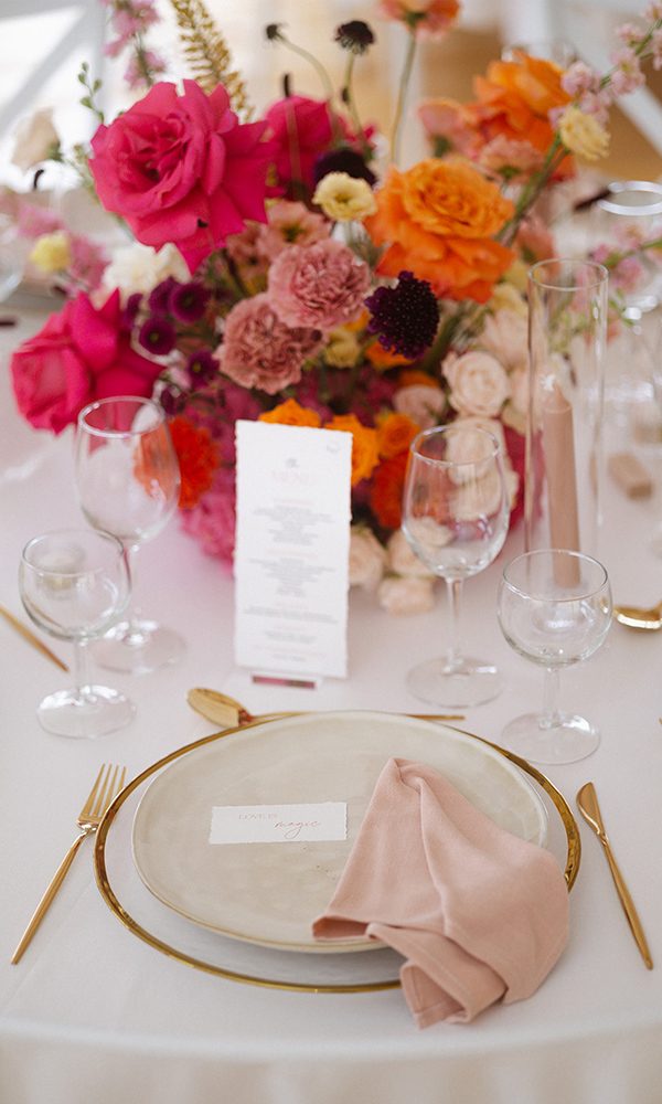 Detailaufnahme eines Hochzeitstisches mit Menükarte und romantischen Akzenten.