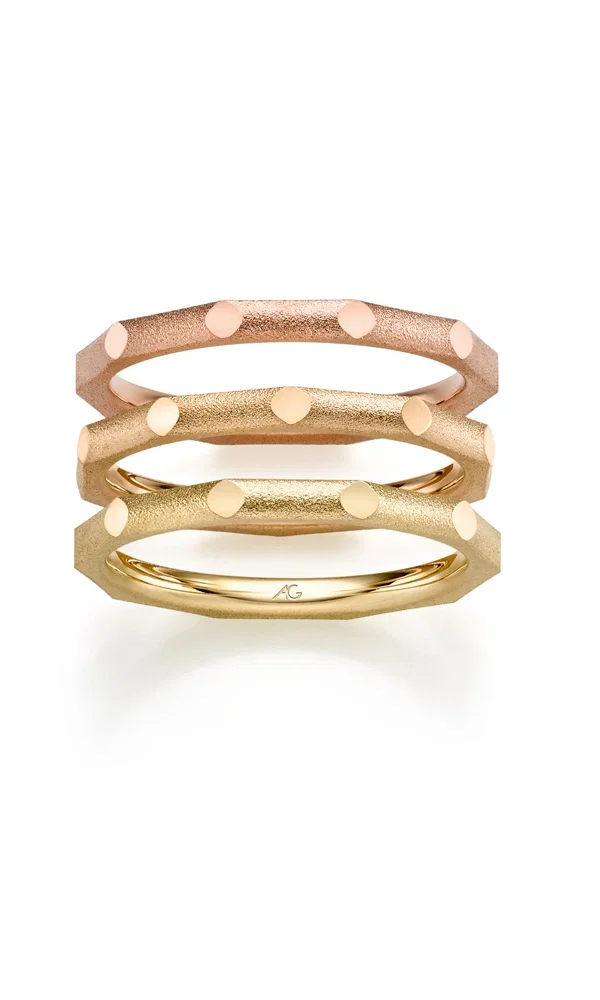 Ein Set aus drei modern designten Eheringen in Roségold, Gelbgold und Champagnergold mit markanten Kanten und polierten Details. Die mattierte Oberfläche betont die geometrische Struktur der Ringe.