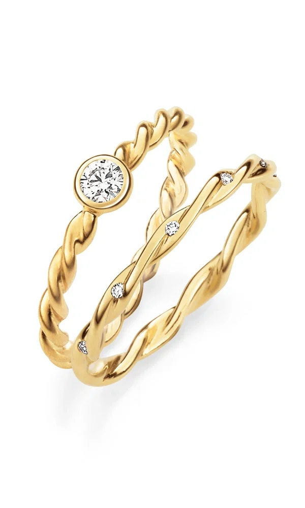 Stilvolles Duo aus gewundenen Goldringen mit Diamantbesatz. Der eine Ring hebt sich durch einen markanten Mittelstein in runder Fassung hervor, während der zweite mit kleinen Brillanten entlang der sanft geschwungenen Linien dezent funkelt.