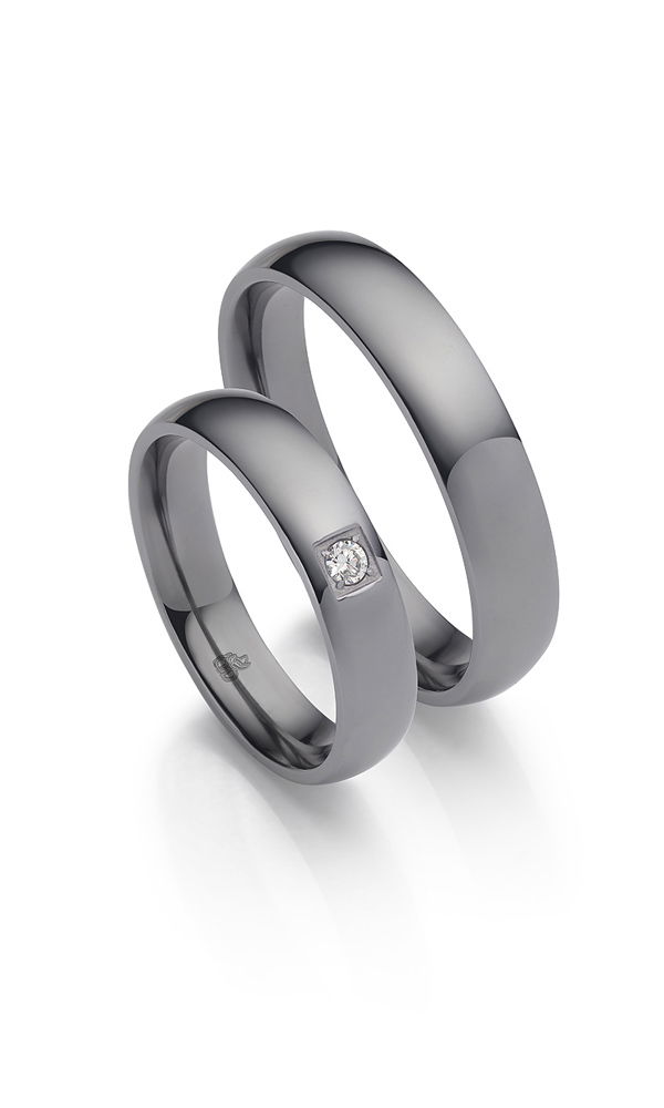 Zeitloses Ehering-Set mit tiefem Anthrazit-Ton und schlichter Eleganz. Der markante Damenring wird durch einen dezent gefassten Diamanten ergänzt, während der Herrenring mit seiner puristischen Form überzeugt.