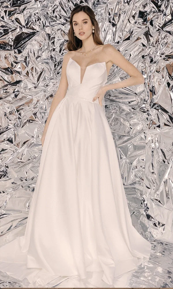 Zeitloses Brautkleid mit voluminösem Rock und dezentem Design, perfekt inszeniert vor einer schimmernden, futuristischen Kulisse.