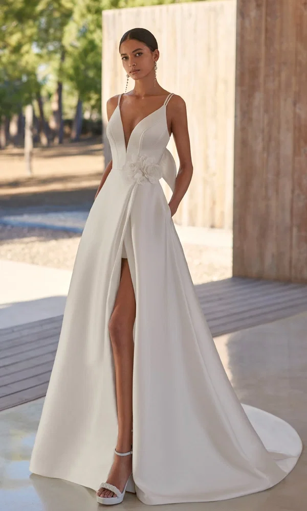 Stilvolles Kleid mit auffälligem Ausschnitt und hoher Beinfreiheit, das durch seine elegante Schlichtheit in einem hellen, offenen Raum besticht.