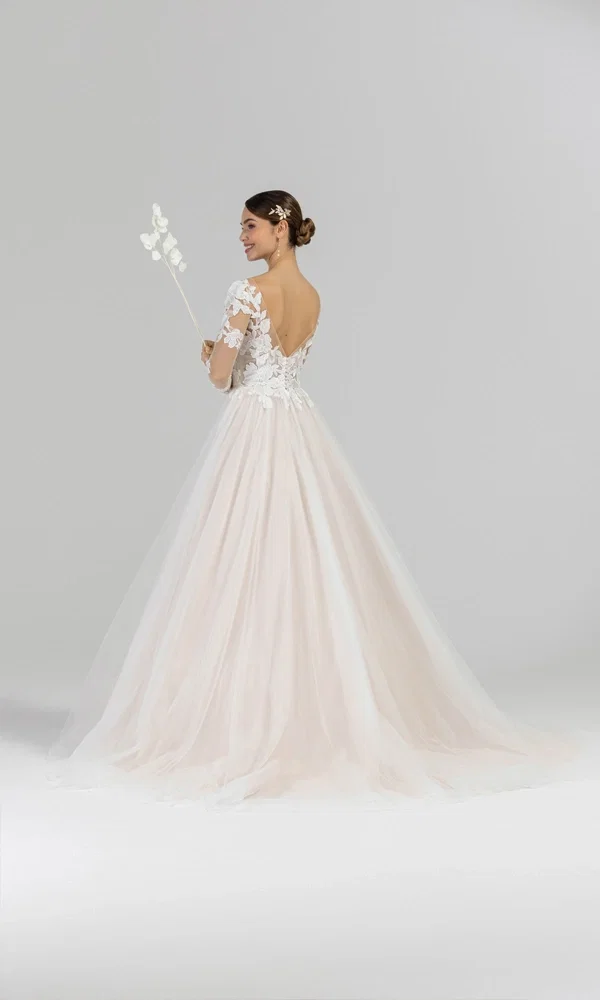 Feminines Brautkleid mit illusionären Spitzenärmeln, zartem V-Ausschnitt und einer langen Schleppe. Der feine Tüll und die floralen Details unterstreichen den eleganten Stil.