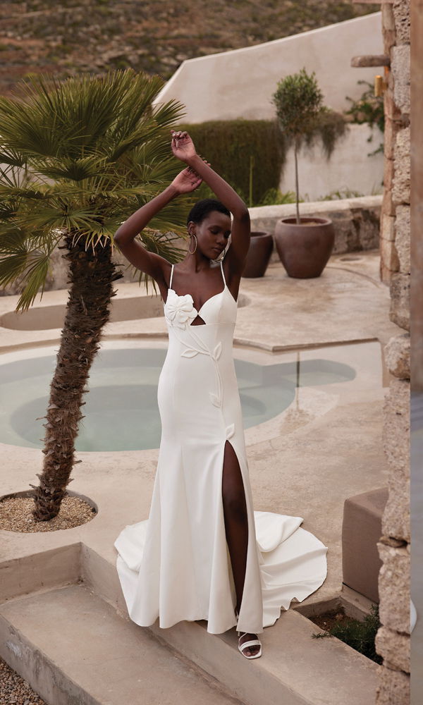 Stilvolles Kleid mit Spaghetti-Trägern und geschlitztem Rock, perfekt in einer luxuriösen, natürlichen Umgebung inszeniert.