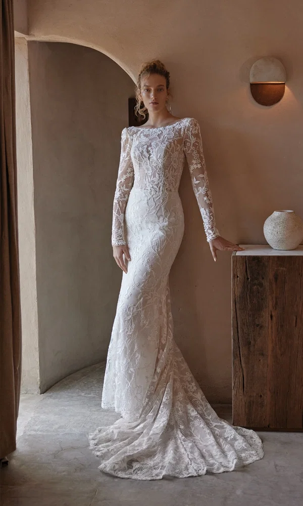 Zeitloses Kleid aus Spitze mit langen Ärmeln und klassischen Details, perfekt für eine intime und stilvolle Hochzeit.